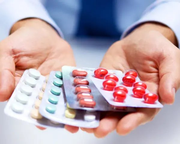 Hände halten Blisterpackungen mit Medikamenten. Möglicherweise zur Linderung von Nervenschmerzen.