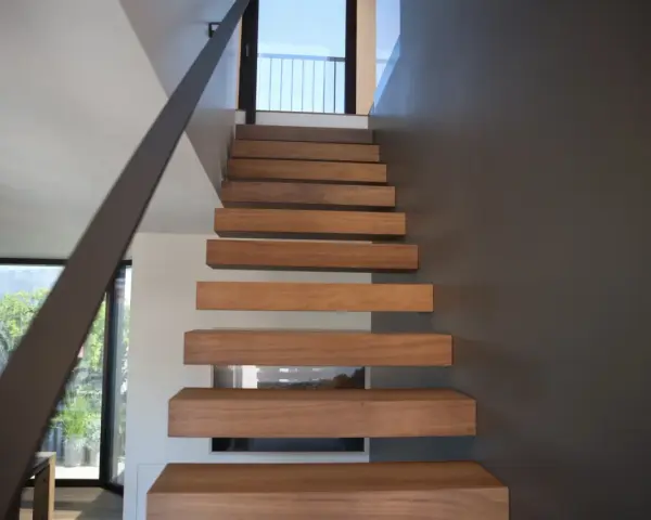 Moderna scala interna con gradini in legno sospesi, un'idea di design minimalista e funzionale.