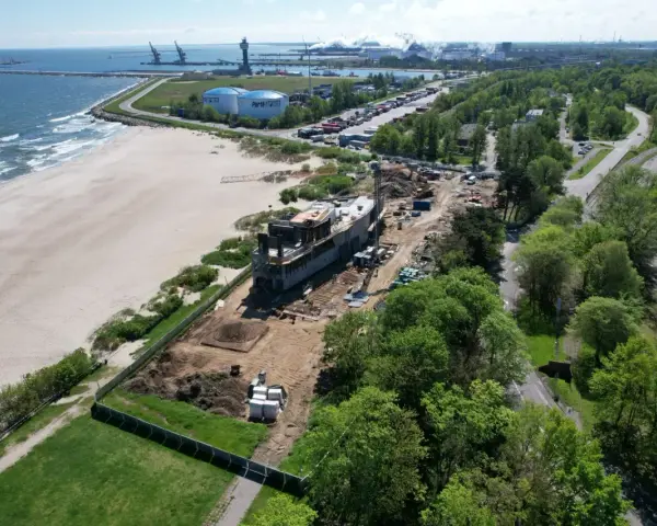 Budowa obiektu przy plaży, w tle port i morze. Idealne miejsce na parking z widokiem na morze.