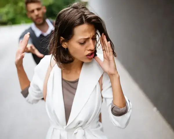 Frau wehrt Mann ab, der sie festhalten will. Ein trauriger Moment, der auf eine bevorstehende Aufhebung der Ehe hindeutet.
