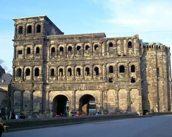 The Porta Nigra, a magnificent example of Trier Roman ruins, stands tall with its imposing stone structure and arched gateways.