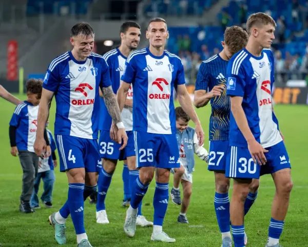 Piłkarze Wisły Płock w niebiesko-białych strojach, gotowi do rozgrywek.