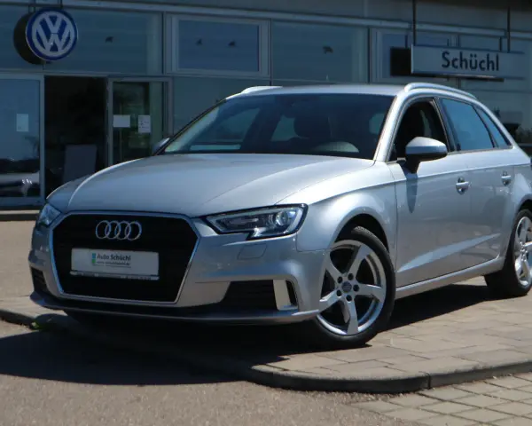 Silberner Audi A3 Avant steht vor einem Autohaus.