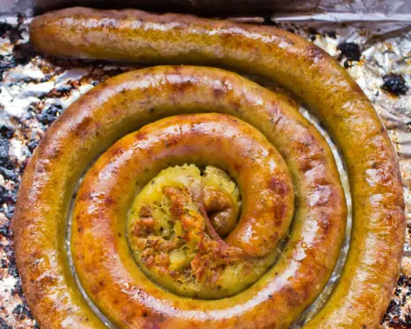 Złocista kiszka ziemniaczana z piekarnika, zawinięta w apetyczny kształt. W środku widać bogate nadzienie.