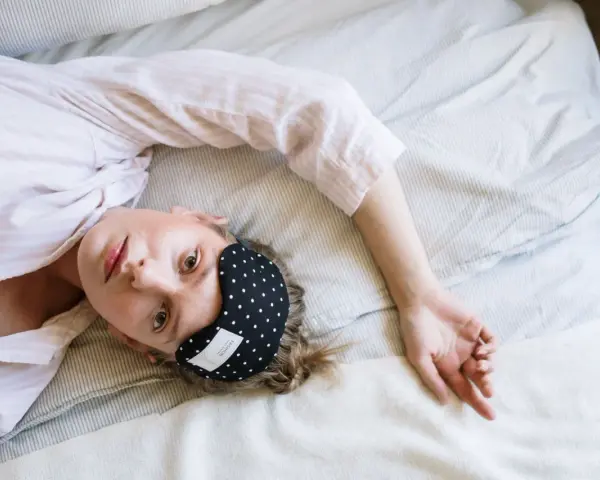 Donna con mascherina per dormire, cerca rimedi per l'insonnia da stress.