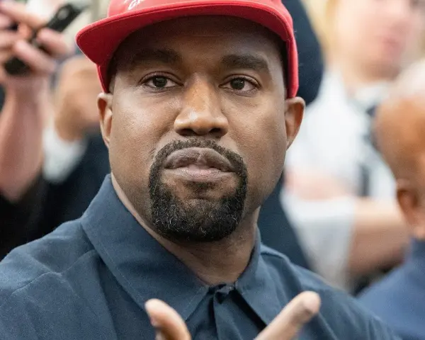 Kanye West w czerwonej czapce i granatowej koszuli, podczas wywiadu.