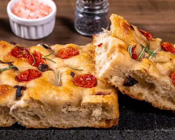 Pyszna, oryginalna włoska focaccia z pomidorkami i rozmarynem. Idealna na przekąskę lub dodatek do dania.