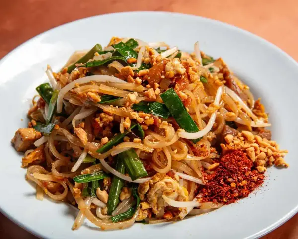 Pyszny pad thai z ryżowym makaronem, kiełkami, orzeszkami i chili. Idealny makaron do pad thai to cienki, płaski ryżowy.