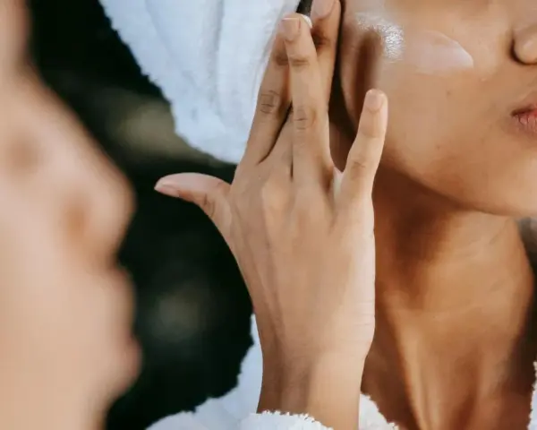 Donna applica crema viso con hydroxypinacolone retinoate, per una pelle luminosa e giovane.