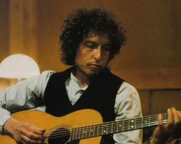 Bob Dylan gra na gitarze, tworząc swoje legendarne utwory.
