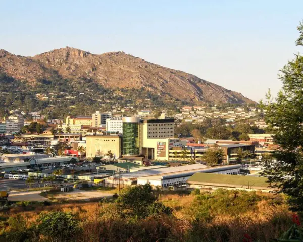 Widok na miasto Mbabane, z górami w tle. Budynki mieszkalne i komercyjne tworzą krajobraz z Mbabane.