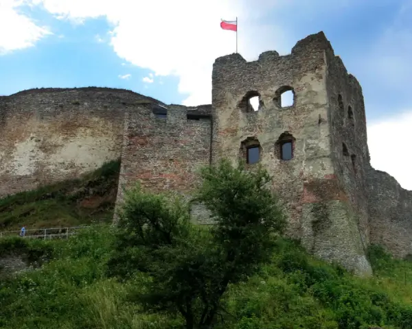 Zamek Czorsztyn, majestatyczne ruiny na wzgórzu, dumnie prezentuje polską flagę na tle błękitnego nieba.