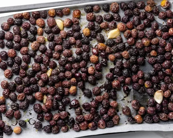 Olive nere al forno alla pugliese, dorate e profumate con aglio, pronte per essere gustate.