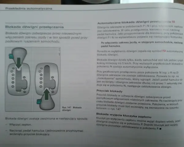 Schemat blokady dźwigni w Audi z tiptronic. Pokazuje, jak nacisnąć hamulec, by odblokować dźwignię.