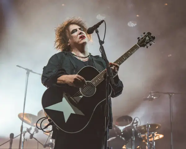 Robert Smith von The Cure spielt auf einer Gitarre mit weißem Stern.