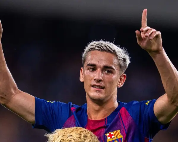 Pablo Gavi, con el pelo teñido de rubio, levanta los brazos y señala al cielo, celebrando un gol.