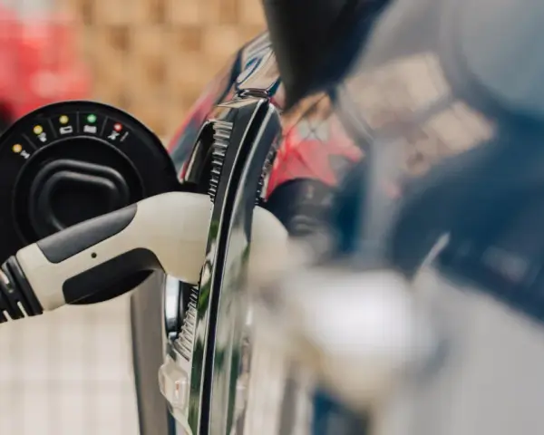 Ładowanie samochodu elektrycznego do 30 tys. zł. Wtyczka z żółtym kablem podłączona do portu ładowania.
