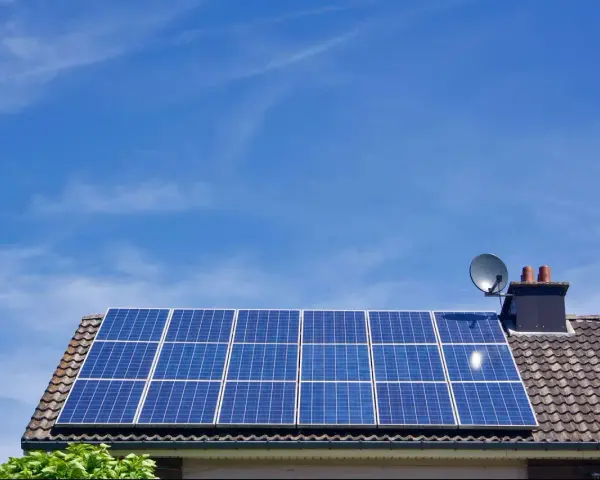 Panele fotowoltaiczne na dachu domu, symbolizujące długą żywotność i ekologiczne pozyskiwanie energii.