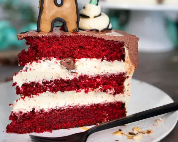 Ein Stück saftiger Red Velvet Cake mit cremiger Füllung, perfekt für das red velvet cake rezept original.