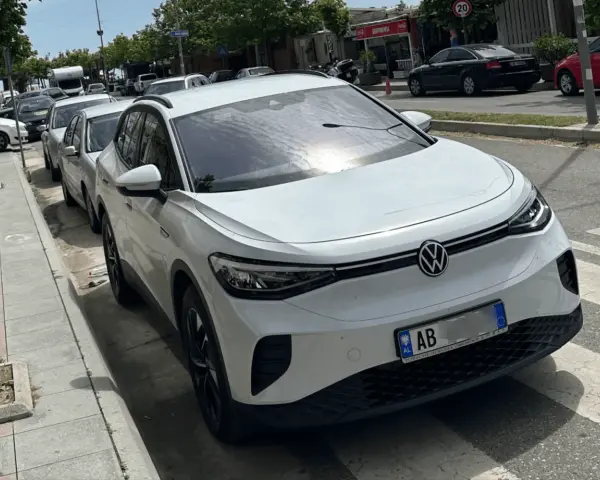 Weißer VW ID.4 mit albanischem Kennzeichen, bereit für seine nächste Fahrt als Taxi in Albanien.