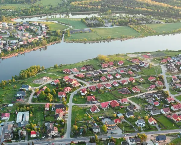 Widok z lotu ptaka na malownicze jezioro Pniewy otoczone zielenią i zabudowaniami.