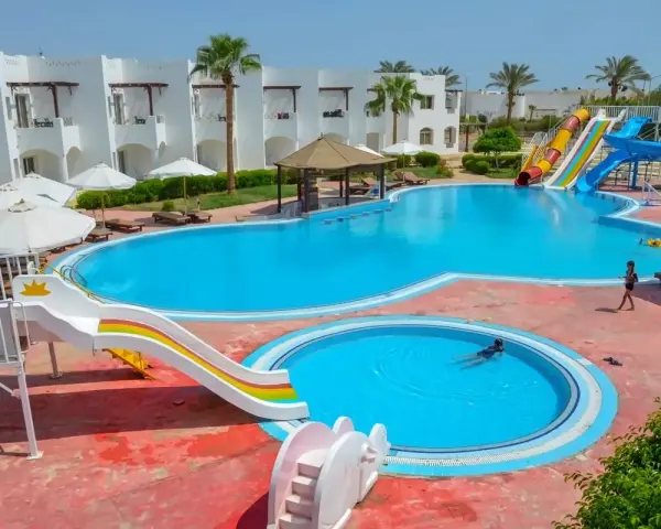 Egipt last minute all inclusive najtaniej: basen z wodnymi zjeżdżalniami i palmami, idealny na wakacje.