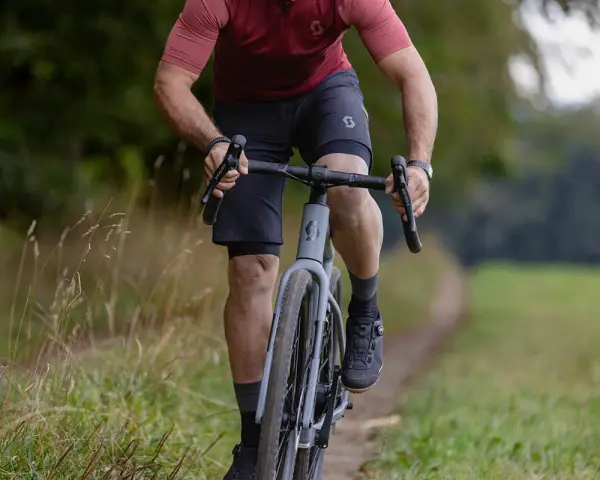 A cyclist rides on a gravel path, showing how many calories 10 minutes of cycling burns.