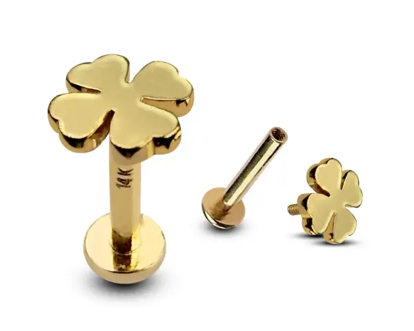 Złoty kolczyk w uchu tragus w kształcie czterolistnej koniczynki. 14K.