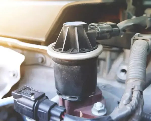 Dettaglio di un componente del motore, la valvola EGR, con connettori elettrici e tubi nelle vicinanze.
