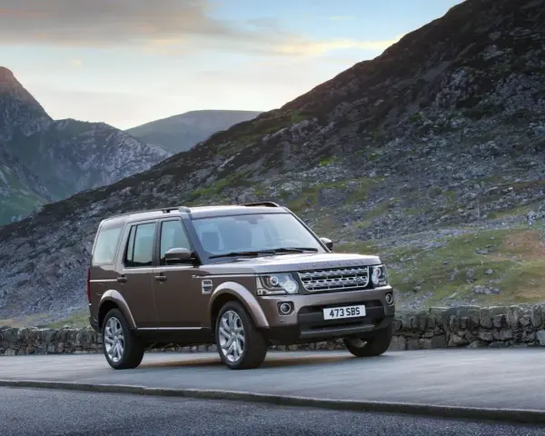 Brązowy Land Rover Discovery 4 na tle górskich krajobrazów. Nawet w tak malowniczym miejscu mogą pojawić się land rover discovery 4 awarie i problemy.