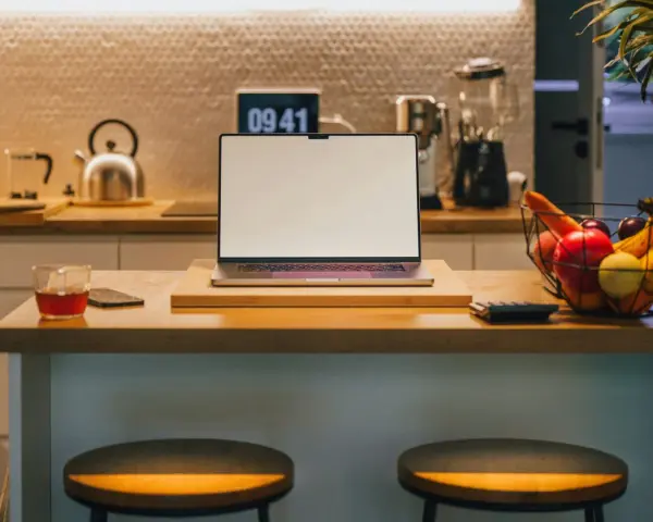Ein Laptop steht auf einer Küchentheke neben Obst und einem Glas Tee. Vielleicht fragst du dich, was Bixby ist – ein digitaler Assistent, der dir bei vielen Dingen helfen kann.
