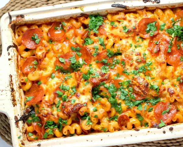 Zapiekanka makaronowa z serem, pepperoni i natką pietruszki w naczyniu żaroodpornym.
