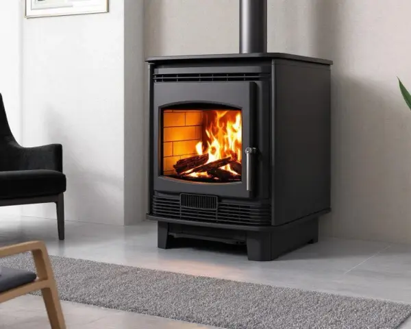 Poêle à bois moderne, flammes vives réchauffant la pièce. Les granulés ne tombent plus, juste du bois qui crépite. Un fauteuil noir et une plante verte complètent la scène.