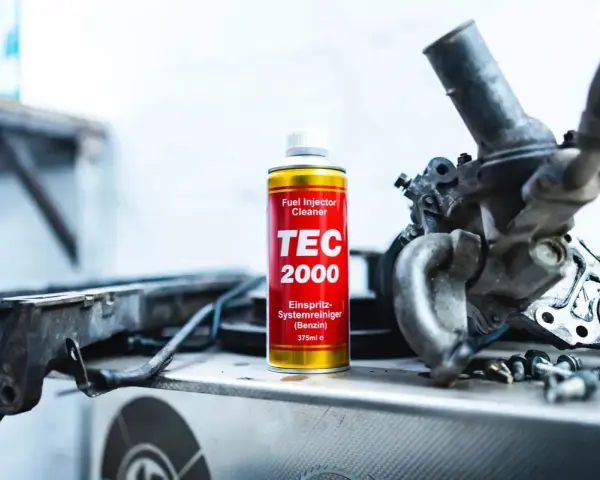 TEC 2000 płukanka do wtryskiwaczy obok rozebranego silnika.