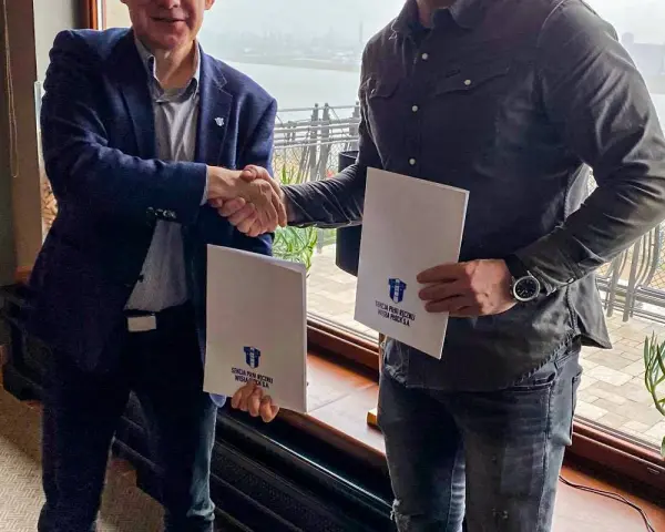Mirsad Terzić i partnerzy podpisują dokumenty. Uściski dłoni i białe teczki z logo klubu.