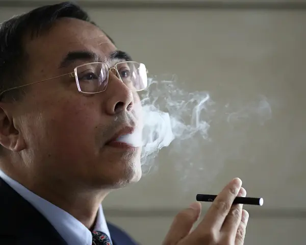 Herbert A. Gilbert exhala vapor de un cigarrillo electrónico.