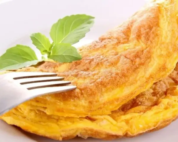 Puszysty omlet z piekarnika, złocisty i lekki, z gałązką bazylii. Idealny na śniadanie.
