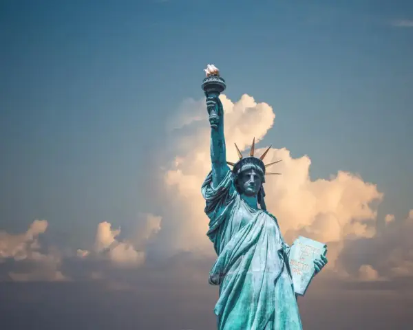 Statua Wolności z pochodnią w górze, symbol USA. Planujesz podróż? Pamiętaj o ubezpieczeniu turystycznym USA.