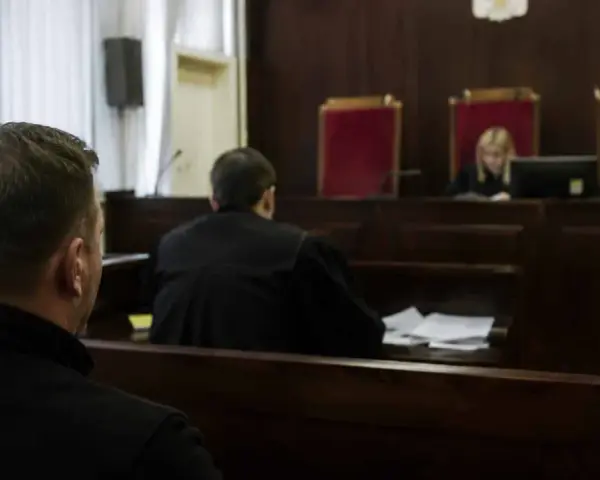 W sali sądowej mężczyzna czeka na rozprawę. Ile trwa sprawa karna?