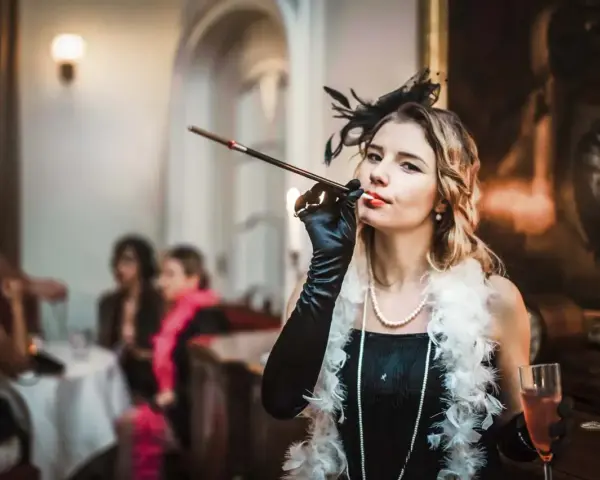 Kobieta w stylu lat 20. z cygaretką i piórami, na tle imprezy.