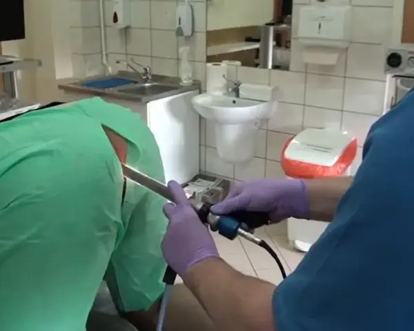 Lekarz w rękawiczkach wykonuje badanie jelit za pomocą endoskopu.