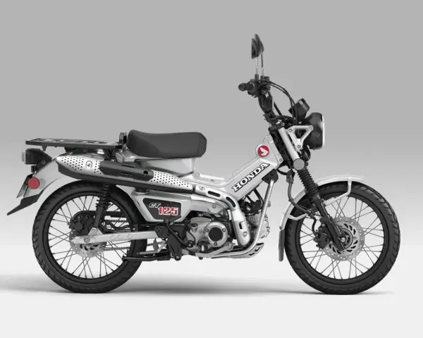 Srebrny motocykl Honda CT 125 z czarnym siedzeniem i bagażnikiem, gotowy na przygodę.