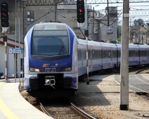 Niebiesko-biały pociąg PKP Intercity ED160-020b stoi na stacji.