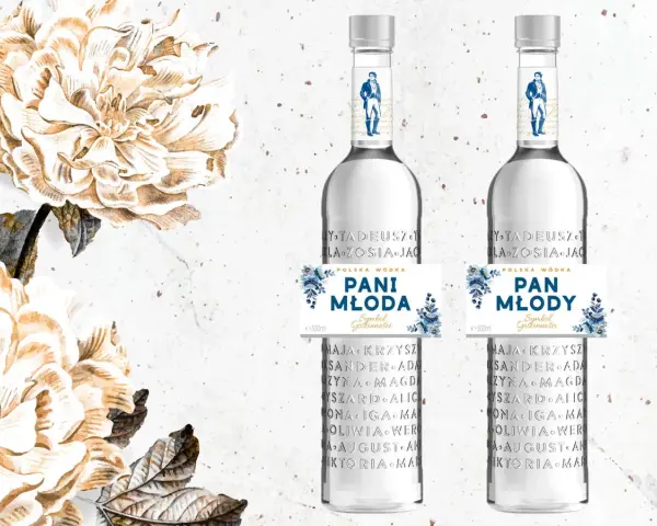 Dwie butelki polskiej wódki "Pan Tadeusz" z etykietami "Pani Młoda" i "Pan Młody", ozdobione kwiatami.