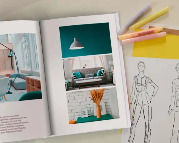 Otwarta księga prezentuje inspiracje do wzornictwa studia: projekt wnętrza i szkice modowe.