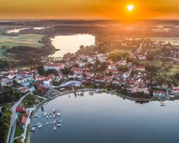 Malownicze miasteczko nad jeziorem o zachodzie słońca. Idealne miejsce na wykorzystanie bonu turystycznego i odpoczynek.