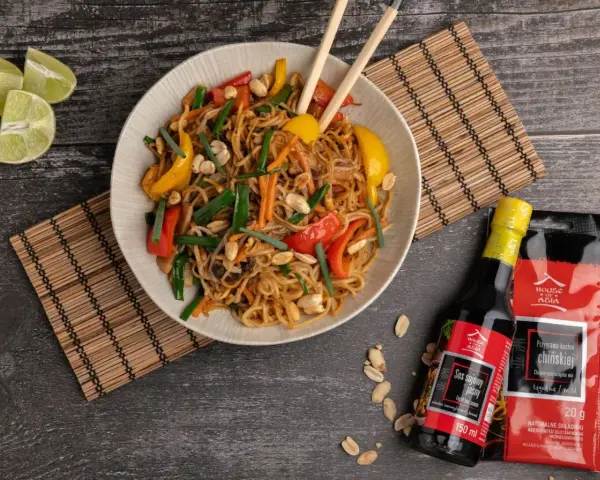 Kolorowy makaron wok z warzywami i orzeszkami ziemnymi, podany z sosami House of Asia.