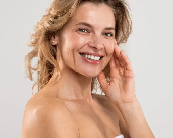 Uśmiechnięta kobieta z blond włosami, która odkrywa swoje naturalne domowe sposoby na zmarszczki.