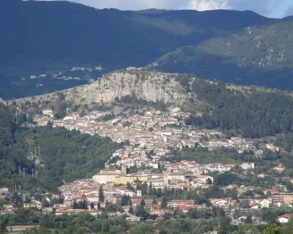 Borgo abruzzese arroccato su un colle, tra boschi e montagne. Immagina il **cammino dei briganti Abruzzo** che attraversa questi sentieri selvaggi.