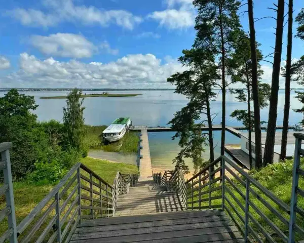 Schody prowadzą do jeziora, gdzie cumuje statek. Idealne miejsce, by zapytać: gdzie na Mazury?